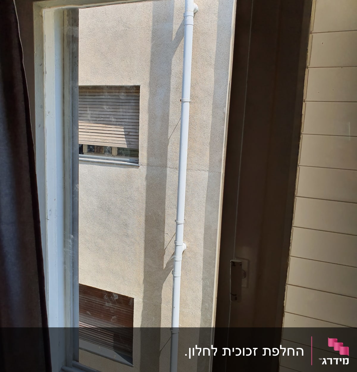 חלון זכוכית פתוח עם מסגרת לבנה